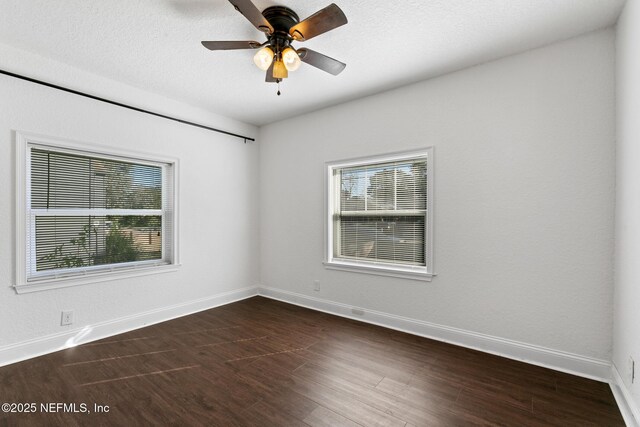 empty room featuring ceiling fan and dark wood-type flooring