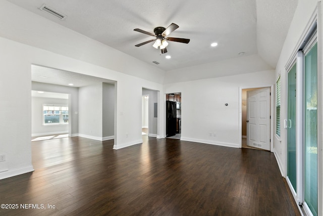 unfurnished room featuring dark wood-type flooring, ceiling fan, vaulted ceiling, and a textured ceiling