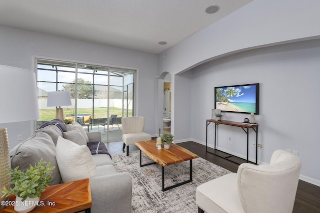 living room with dark hardwood / wood-style floors and a textured ceiling