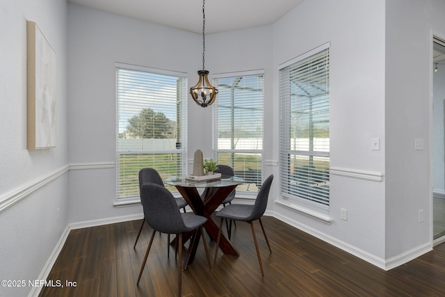 dining area featuring dark hardwood / wood-style floors and a chandelier