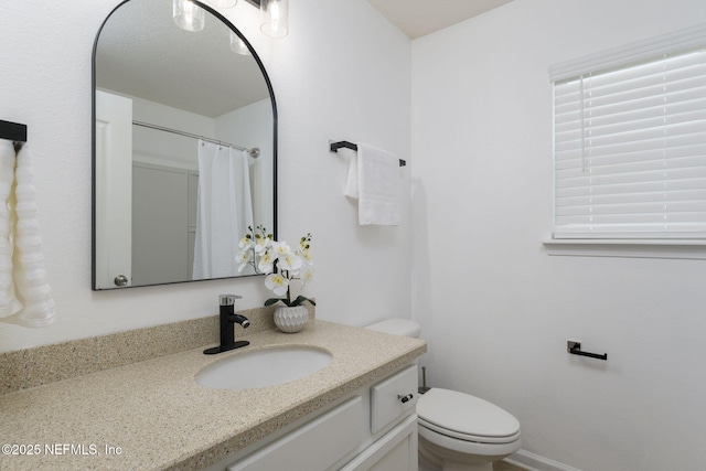 bathroom with vanity, curtained shower, and toilet