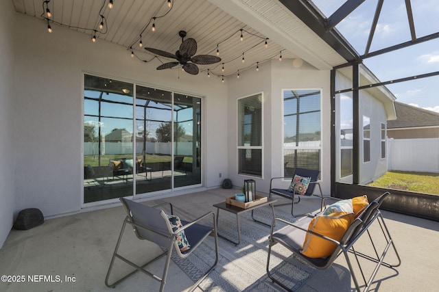 view of patio with ceiling fan and glass enclosure