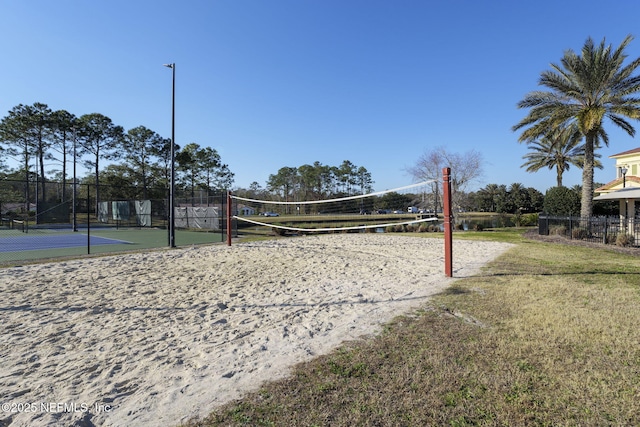 view of community featuring tennis court and a lawn