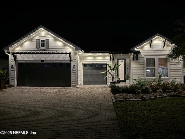 view of front of home with a garage and decorative driveway