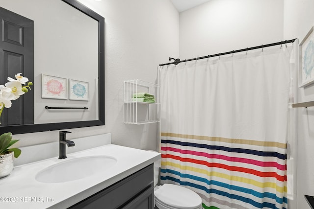 bathroom featuring toilet, curtained shower, and vanity