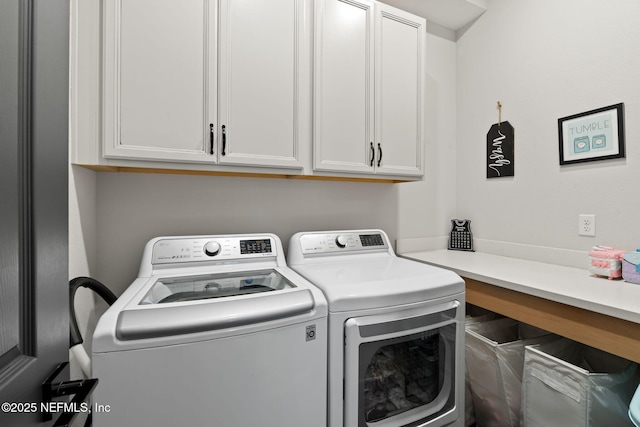 washroom with washer and clothes dryer and cabinet space