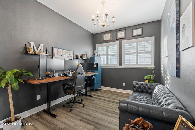 office featuring lofted ceiling, a notable chandelier, wood finished floors, and baseboards