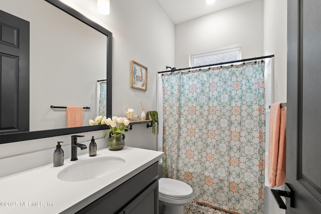 full bathroom with curtained shower, vanity, and toilet