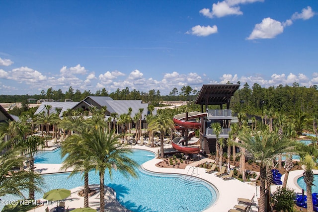 community pool featuring a water slide and a patio area