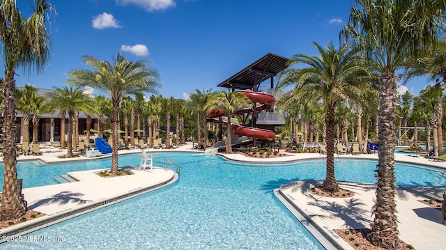 pool with a water slide and a patio area