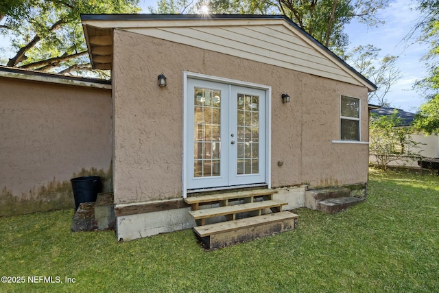 property entrance with a lawn and french doors