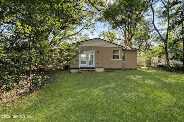 back of house with a yard and french doors