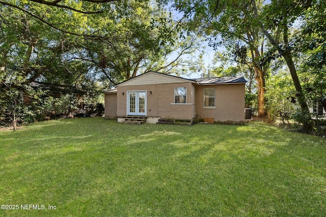 rear view of house featuring a yard and french doors