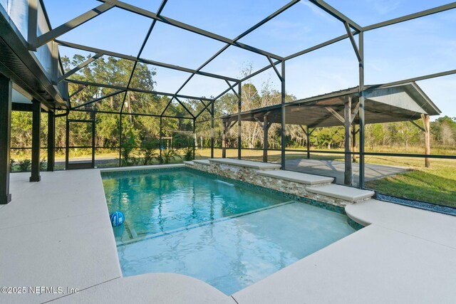 view of pool with pool water feature, glass enclosure, and a patio