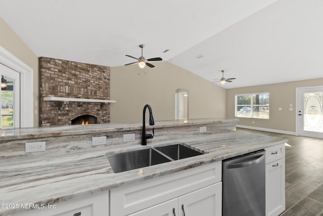 kitchen with dishwasher, light stone countertops, lofted ceiling, and sink