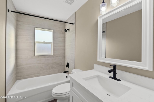 full bathroom with vanity, tiled shower / bath combo, and toilet