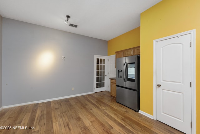 kitchen with stainless steel fridge and light hardwood / wood-style floors