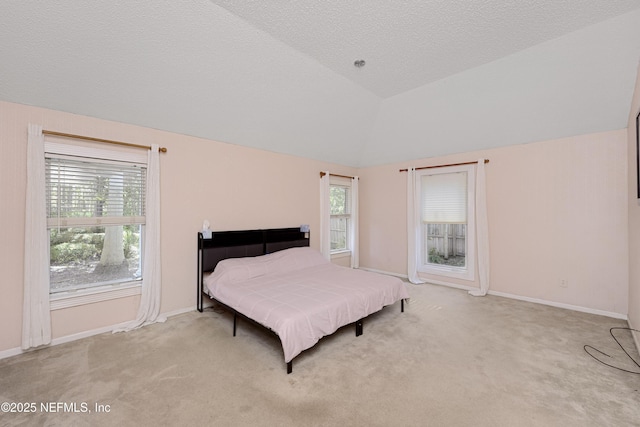 carpeted bedroom with multiple windows, high vaulted ceiling, and a textured ceiling