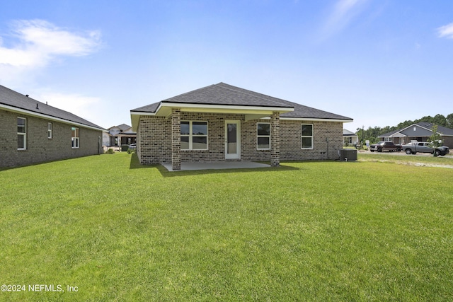 rear view of house with a lawn, a patio, and central AC unit