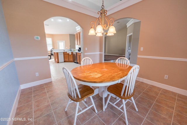 tiled dining space with sink and a chandelier