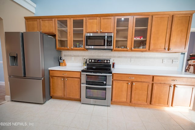 kitchen featuring appliances with stainless steel finishes, backsplash, and light tile patterned flooring