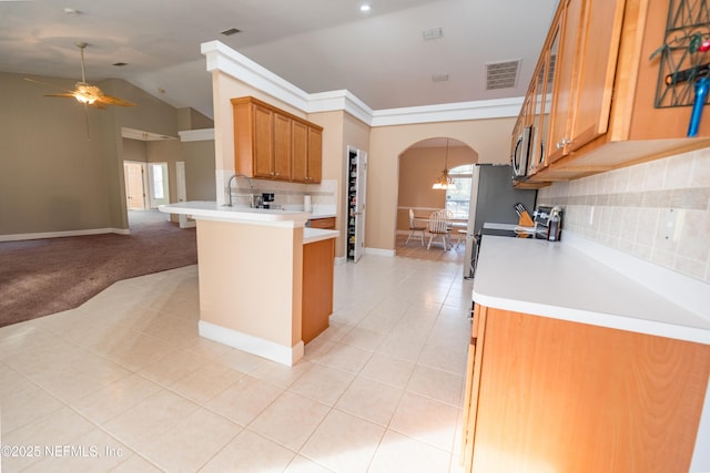 kitchen featuring kitchen peninsula, light carpet, backsplash, ceiling fan, and lofted ceiling