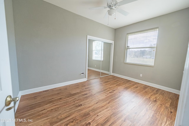 unfurnished bedroom featuring hardwood / wood-style flooring, ceiling fan, and a closet