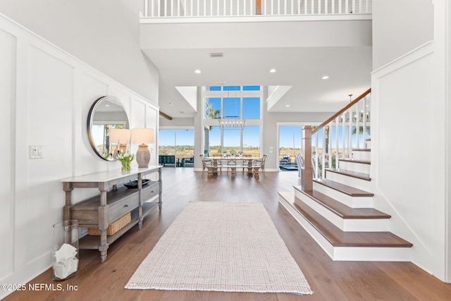 foyer featuring hardwood / wood-style flooring and a towering ceiling