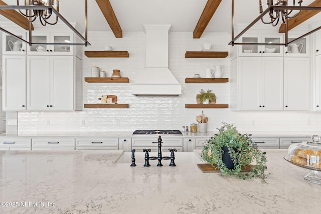 kitchen featuring light stone countertops and white cabinetry