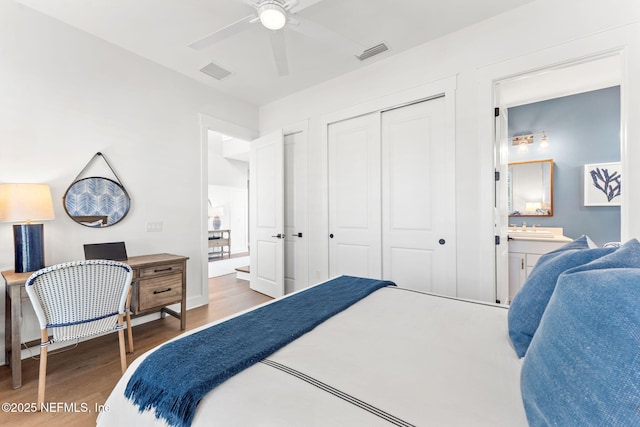 bedroom featuring ceiling fan, dark hardwood / wood-style flooring, sink, connected bathroom, and a closet