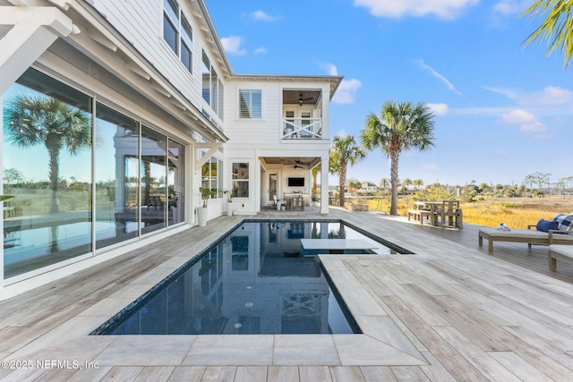 view of swimming pool with ceiling fan and a wooden deck