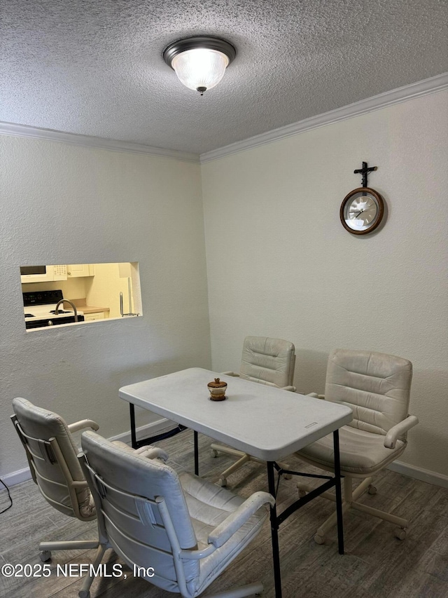 dining space featuring wood-type flooring, a textured ceiling, and crown molding