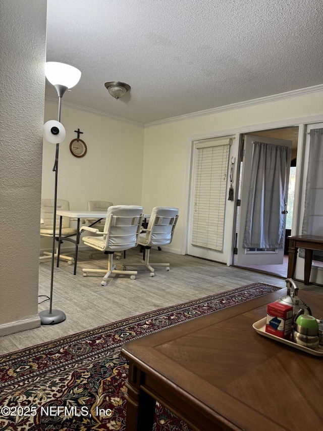 interior space with hardwood / wood-style flooring, ornamental molding, and a textured ceiling