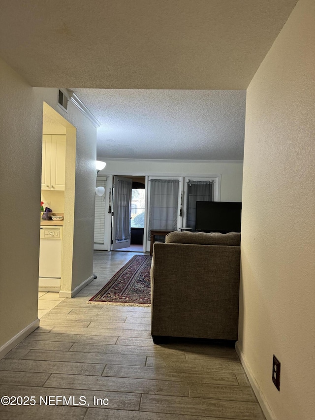 unfurnished living room with a textured ceiling and light hardwood / wood-style flooring