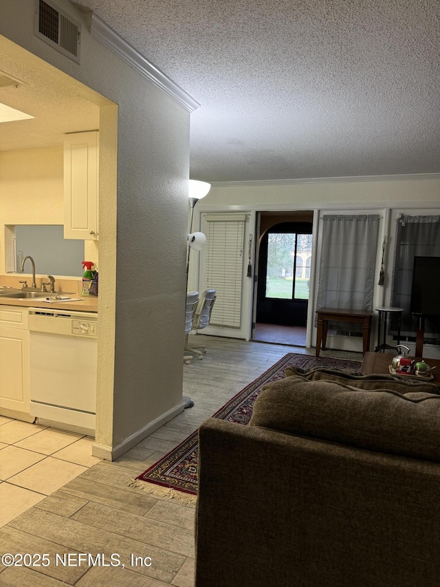 living room featuring a textured ceiling, light hardwood / wood-style floors, crown molding, and sink