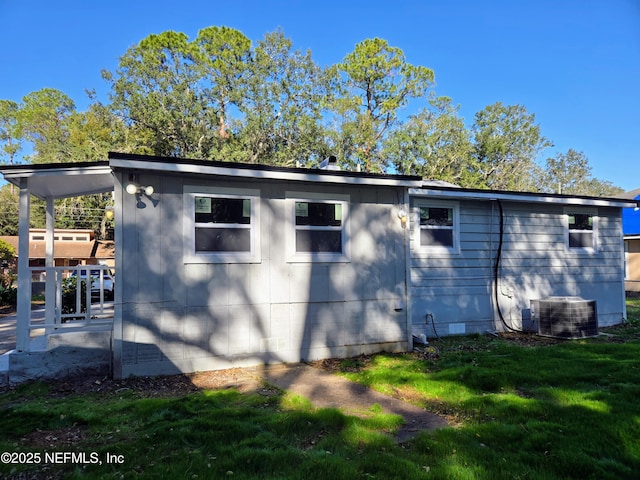 view of side of property with a lawn and central AC