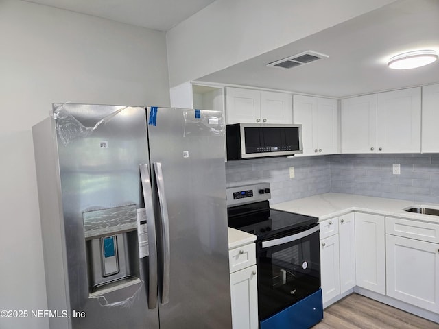 kitchen with white cabinetry, black electric range, light hardwood / wood-style flooring, stainless steel refrigerator with ice dispenser, and decorative backsplash