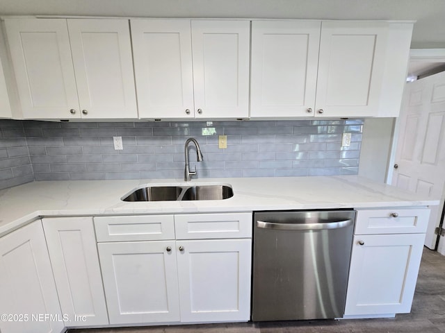 kitchen with stainless steel dishwasher, backsplash, white cabinets, and sink