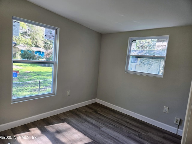 spare room featuring dark hardwood / wood-style floors and a healthy amount of sunlight