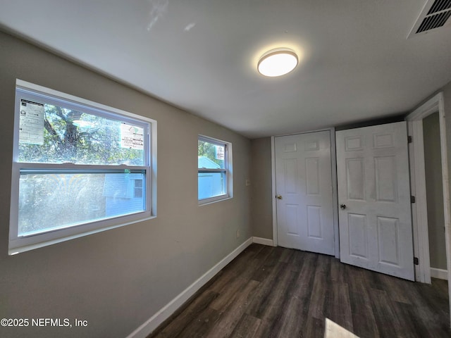 unfurnished bedroom with dark wood-type flooring