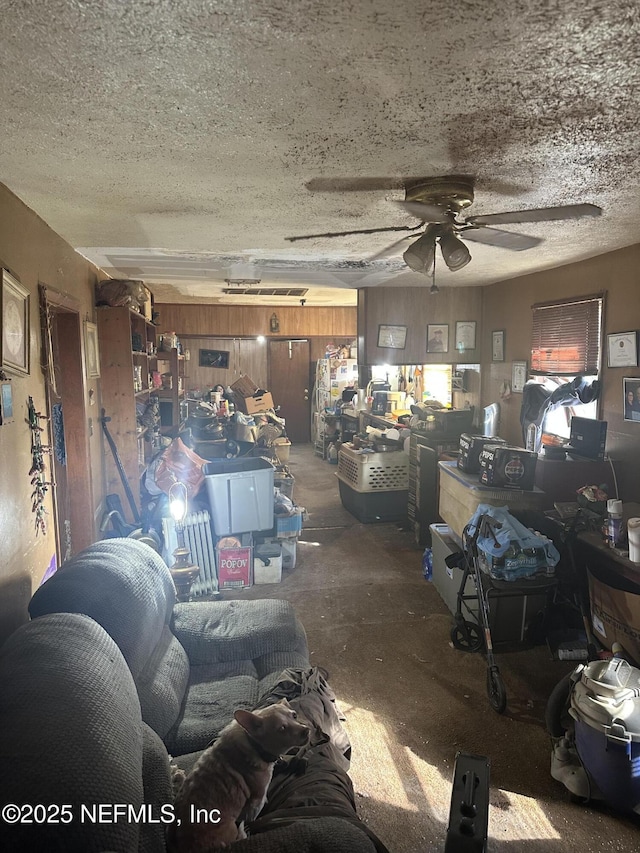 living room with ceiling fan and a textured ceiling