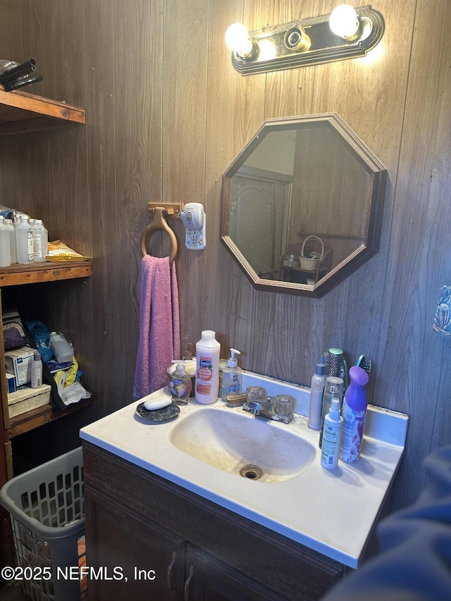 bathroom with wood walls and vanity