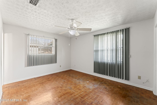 unfurnished room with ceiling fan, parquet floors, and a textured ceiling