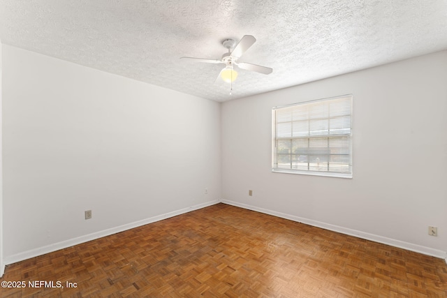 empty room with ceiling fan, dark parquet floors, and a textured ceiling