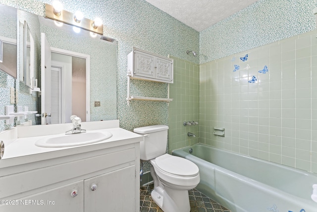 full bathroom with tiled shower / bath combo, vanity, toilet, tile patterned floors, and a textured ceiling