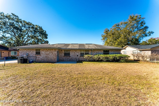 back of property with a patio area and a lawn