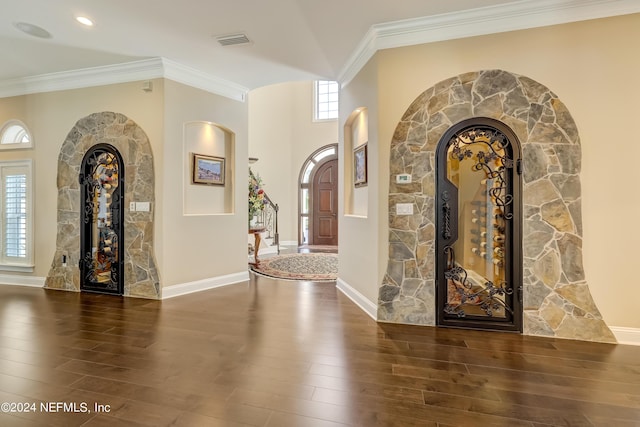 foyer featuring ornamental molding, dark wood finished floors, visible vents, and baseboards