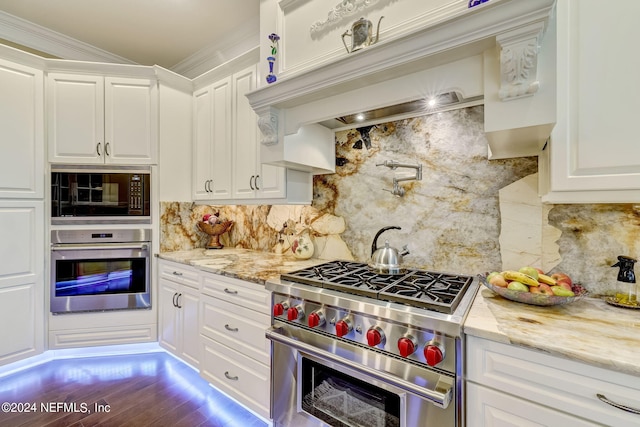 kitchen featuring appliances with stainless steel finishes, white cabinetry, and light stone counters