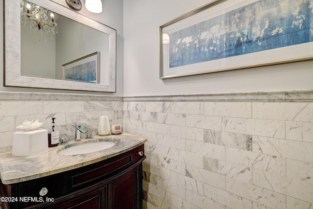 bathroom featuring a wainscoted wall, vanity, and tile walls