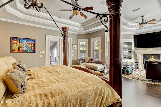 bedroom with hardwood / wood-style flooring, a fireplace, visible vents, and a raised ceiling